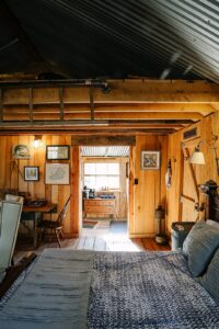 A photograph by Marybeth wells of the interior of a Hipcamp Cabin near Woodstock, Virginia. It's a rustic wooden cabin with a kitchenette and coffee bar.