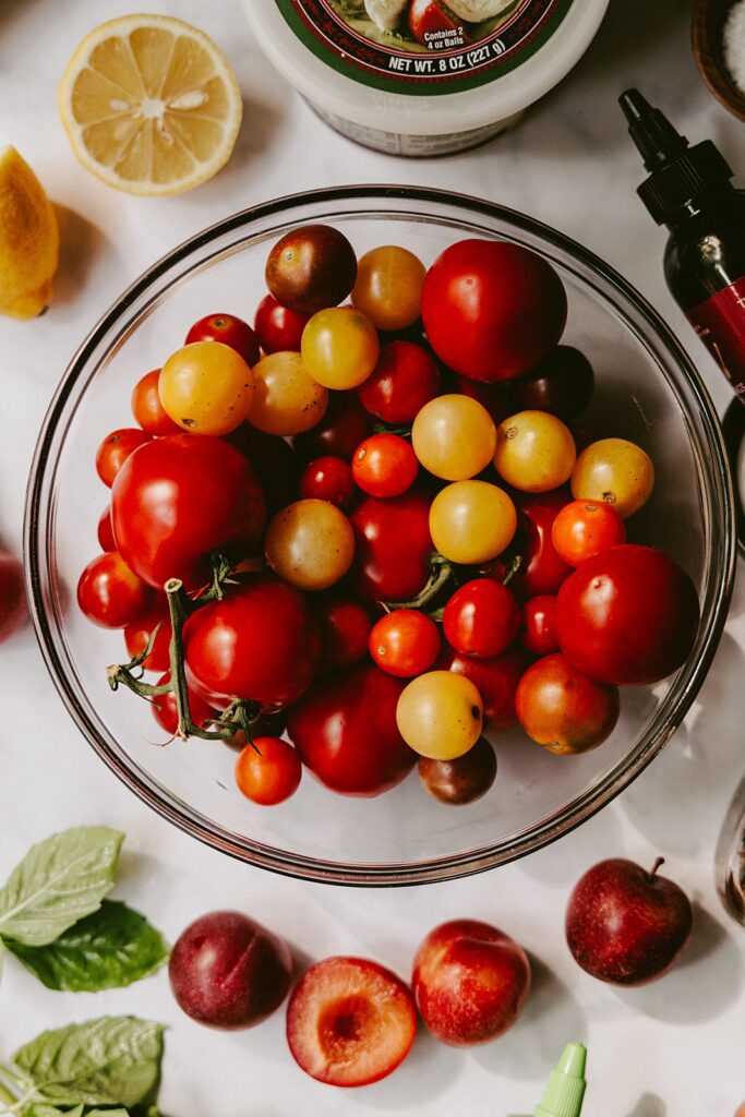 a clear glass bowl of heirloom tomatoes
